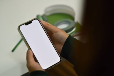 Ofis masasında cep telefonu kullanan bir kadın. Reklam metniniz için beyaz ekran.