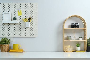 Kahve fincanı, kamera, mumlar, ev bitkisi ve tahta kaplı rahat bir iş yeri..