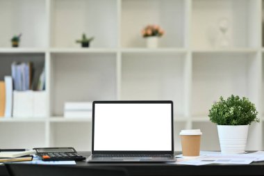 Ofis masasında boş ekran, hesap makinesi ve mali belgeleri olan önizleme dizüstü bilgisayarı.