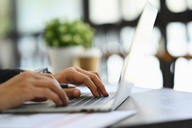 Klavyede yazan, e-postaya cevap veren ya da dizüstü bilgisayardaki bilgileri arayan yakın plan erkek işçi..