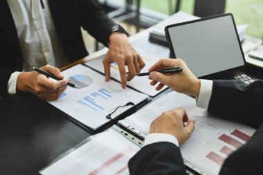 Modern ofiste finans piyasasını analiz eden iki işadamı.