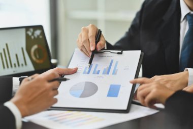 Ofiste pazarlama araştırma sonuçları veya istatistik verileriyle çalışan iki işadamı.