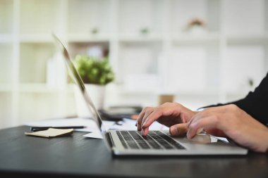 İş adamı elleri klavyede daktilo kullanıyor, iş ortaklarına e-posta gönderiyor ya da bilgi arıyor.