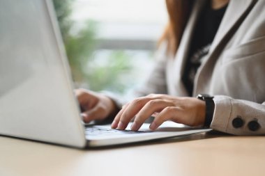 Kapalı iş kadını elleri dizüstü bilgisayarda yazarken e-postaya cevap verirken ya da bilgi ararken.
