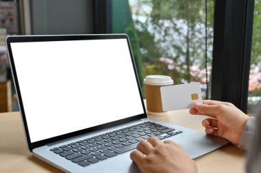 Bilgisayarda internetten sipariş veren kredi kartı olan yakın plan kadın..