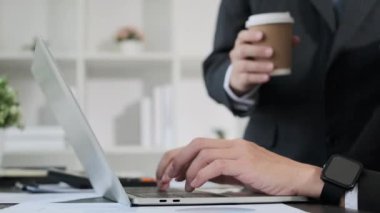 Dizüstü bilgisayar kullanan genç iş adamları, ofiste proje istatistikleri üzerinde işbirliği yapıyorlar..