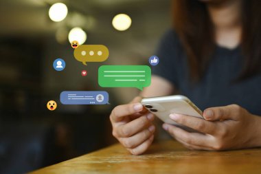 Sosyal medyayı kullanan, yorum yapan ve cep telefonuna yorum yapan genç bir kadın.