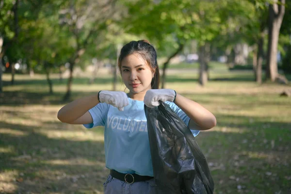 かなりの女性ボランティアが森林ゴミを集め カメラを見ている 世界環境デーコンセプト — ストック写真