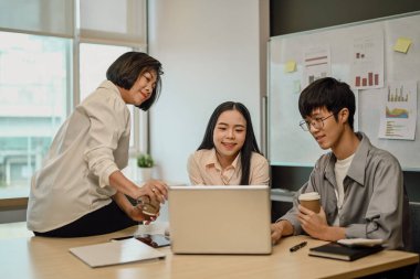 Kıdemli bayan yönetici yeni çalışanlara yardım ve açıklama yapıyor..