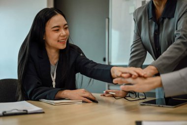 İş ekibinin toplantı masasında el ele toplandığı sahneler. Kurumsal birlik ve dayanışma kavramı.