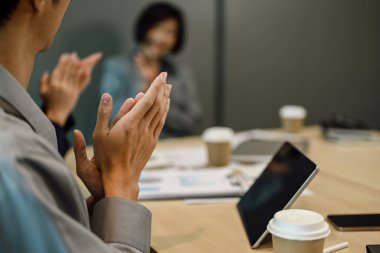 Konferans odasında düzenlenen bir seminerde iş adamlarının alkışladığı kesikli bir görüntü.