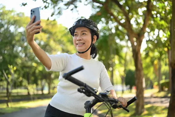 Bisiklette Oturan Cep Telefonuyla Video Görüşmesi Yapan Mutlu Orta Yaşlı — Stok fotoğraf