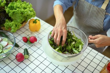 Üst düzey bir adamın mutfakta sağlıklı bir vejetaryen yemeği yapması. Sağlıklı yeme kavramı