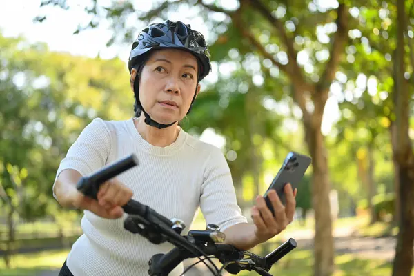 Parkta Bisiklet Süren Cep Telefonu Kullanan Spor Elbiseli Yaşlı Bir — Stok fotoğraf