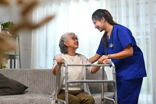 Caring healthcare worker talking while visiting senior woman patient at home. Healthcare concept