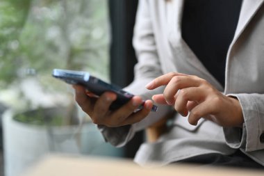 İş kadını sosyal medyayı kontrol ediyor ya da cep telefonundan mesaj yolluyor