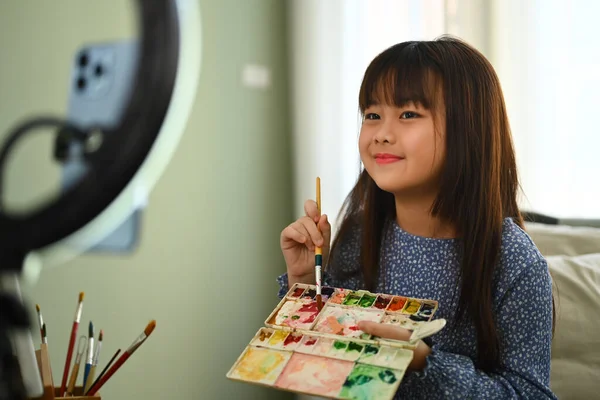 Asian little girl painting picture and recording video to share on social media
