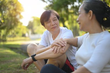 Gün batımında parkta dinlenirken mutlu son sınıf çifti konuşuyor. Sağlık ve İlişki Konsepti