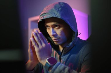 Kapüşonlu erkek hacker dijital ağ sistemine saldırmak için bilgisayar kullanıyor. Siber güvenlik kavramı.