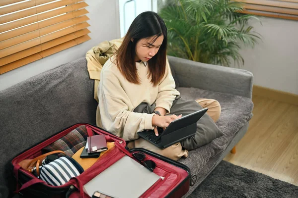 Young woman searching information weekend vacation trip on digital tablet. Travel and vacation concept.