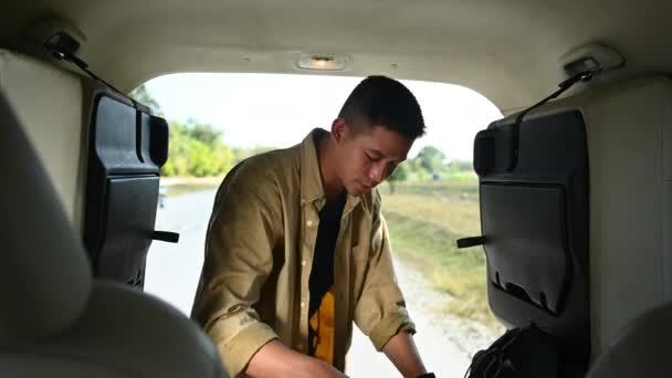 Чоловік Перевіряє Заряджає Сумки Багажнику Автомобіля Перед Початком Сольної Подорожі — стокове відео