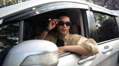 Direksiyonda oturan yakışıklı bir adamın yan görünüş portresi. Yolculuğun tadını çıkarıyor..