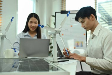 Ofiste sürdürülebilir ve yenilenebilir kaynaklarla enerji geçişi üzerinde çalışan mühendisler..