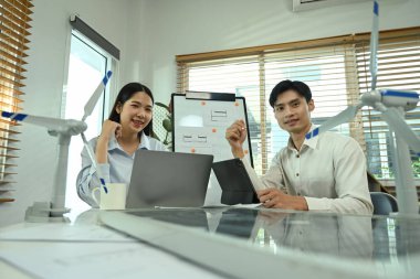 Alternatif enerji mühendisleri ofiste yeni bir projede işbirliği yapıyorlar.