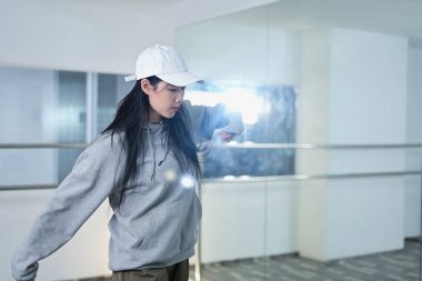 Yetenekli genç bir kadın dans stüdyosunda canlı hip hop hareketleri yapıyor..