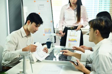 Bir grup mühendis ofiste yeni bir projeyi tartışıyor. Yenilenebilir enerji kavramı.