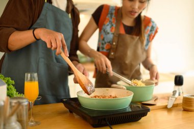 Mutfakta birlikte yemek hazırlarken sohbet eden mutlu genç çift..