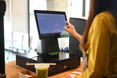 Tezgahta duran bayan garson ödemeyi kabul ediyor ya da kahve dükkanına sipariş detaylarını giriyor..