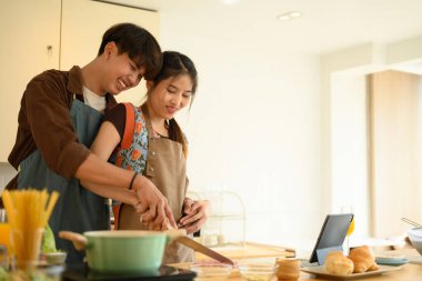 Romantik genç çift evde boş vakit geçirirken spagetti hazırlıyor..