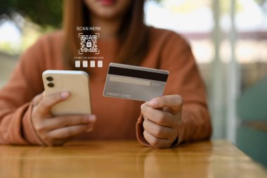 Kadın cep telefonundaki banka hesabına QR doğrulama kodu girişi taranıyor. Siber güvenlik kavramı.