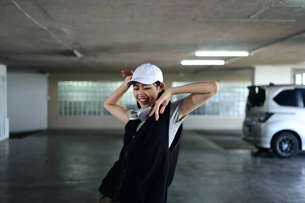 Joyful young woman dancing Hip hop dance in parking garage. Hobby and active lifestyle concept.