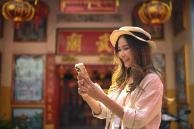 Şehir merkezindeki bir Çin tapınağında cep telefonu kullanan güzel bir bayan gezgin..