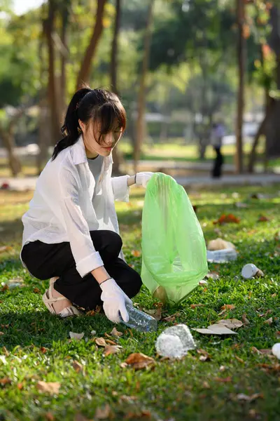 プラスチックボトルを集めて自然を浄化する若い女性のショット チャリティーとエコロジーのコンセプト — ストック写真