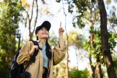 Mutlu genç bir kadının ormanda yürüyüşü ve doğanın tadını çıkarışı..
