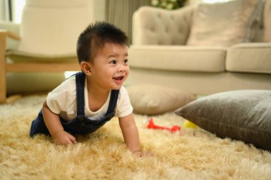 Sıcak oturma odasındaki halının üzerinde sürünen tatlı bir oğlan çocuğu..