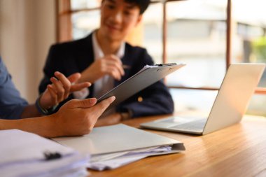 İş dünyası ekibi iş yerinde proje ayrıntılarını ve iş planını tartışıyor.