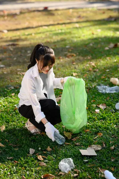 パブリックパークでゴミ拾いをする若い女性 環境責任の概念 — ストック写真