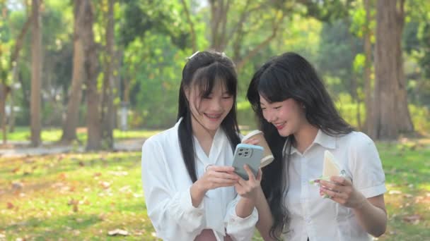 Mutlu Asyalı Bayan Meslektaşların Yemek Arasında Sandviçlerini Yerken Cep Telefonu — Stok video