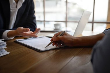 Kapanış avukatı ya da sigorta acentesi erkek müşteriye nereyi imzalayacağını gösteriyor..