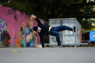 Yetenekli Asyalı erkek dansçı sokakta hip hop dansı yapıyor..