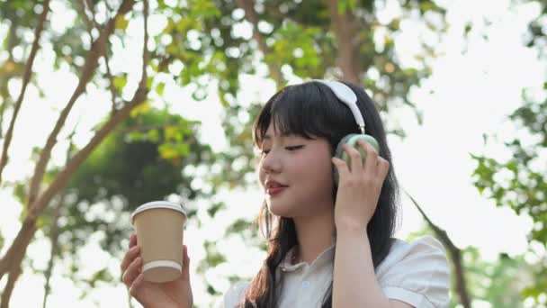 Gülümseyen Asyalı Kadın Yaz Günü Kahve Molasında Sevdiği Şarkıyı Dinliyor — Stok video