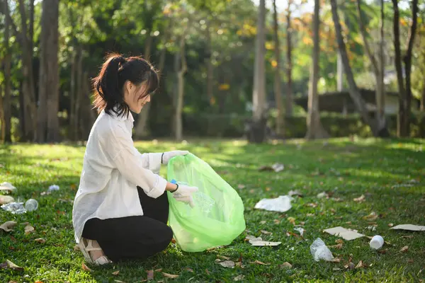 公共の公園でゴミ拾いをする手袋の若い女性 環境ケアコンセプト — ストック写真