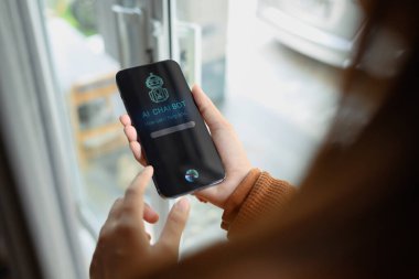 Mobil uygulamalarda Al Chat botu kullanan ve ses komutları veren kadının omuz üstü görüntüsü.