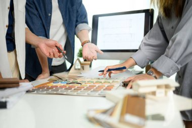 Ofiste malzeme ve renk örnekleriyle çalışan iç mimar ekibinin görüntüsü..