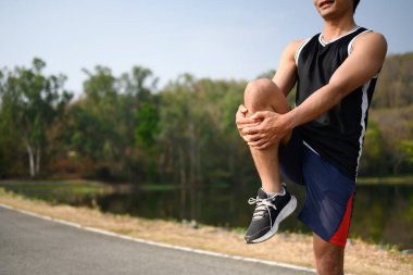 Sportif adam gerinme egzersizleri yapıyor. Parktaki sabah antrenmanına hazırlanıyor..