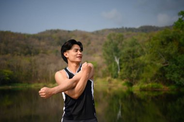 Sportif adam gerinme egzersizleri yapıyor. Parktaki sabah antrenmanına hazırlanıyor..